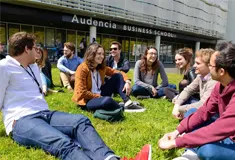 Students sat on grass outside Audencia Business School
