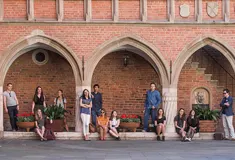Students standing outside a university campus building under arches