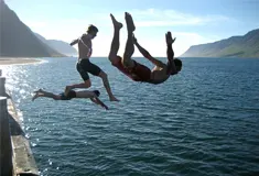Students diving into lake water